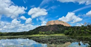 Breathtaking view of Savandurga Hill in Karnataka reflecting in a serene lake.