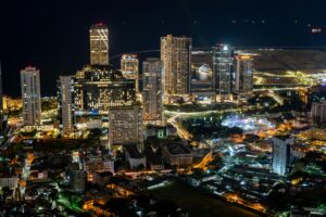 A vibrant aerial view of Colombo's illuminated skyline at night, showcasing modern architecture.